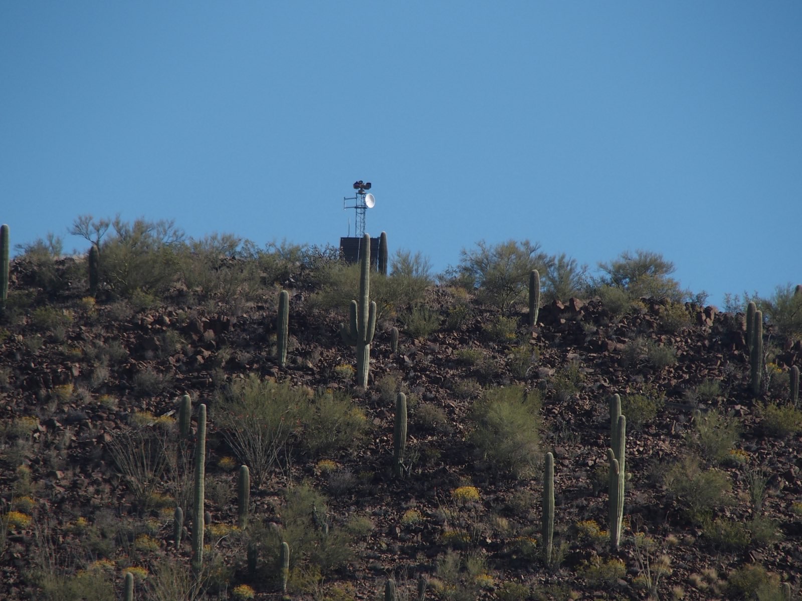 EFF A zoomed-in image of a surveillance tower on a desert hill.